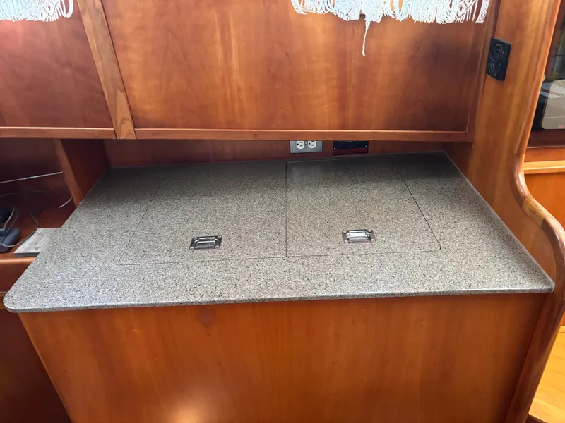 Slide: The Image of 1999 Diesel Duck Trawler interior with wooden cabinetry and granite countertop. - 32