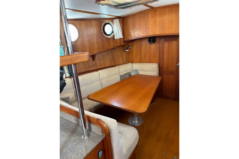 Slide: The Image of Cozy interior of 1999 Diesel Duck Trawler with wooden table and cushioned seating. - 34