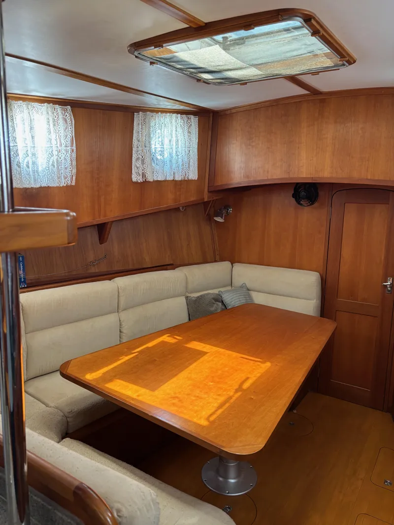 Slide: The Image of Cozy interior of 1999 Diesel Duck Trawler with wooden table and cushioned seating. - 35