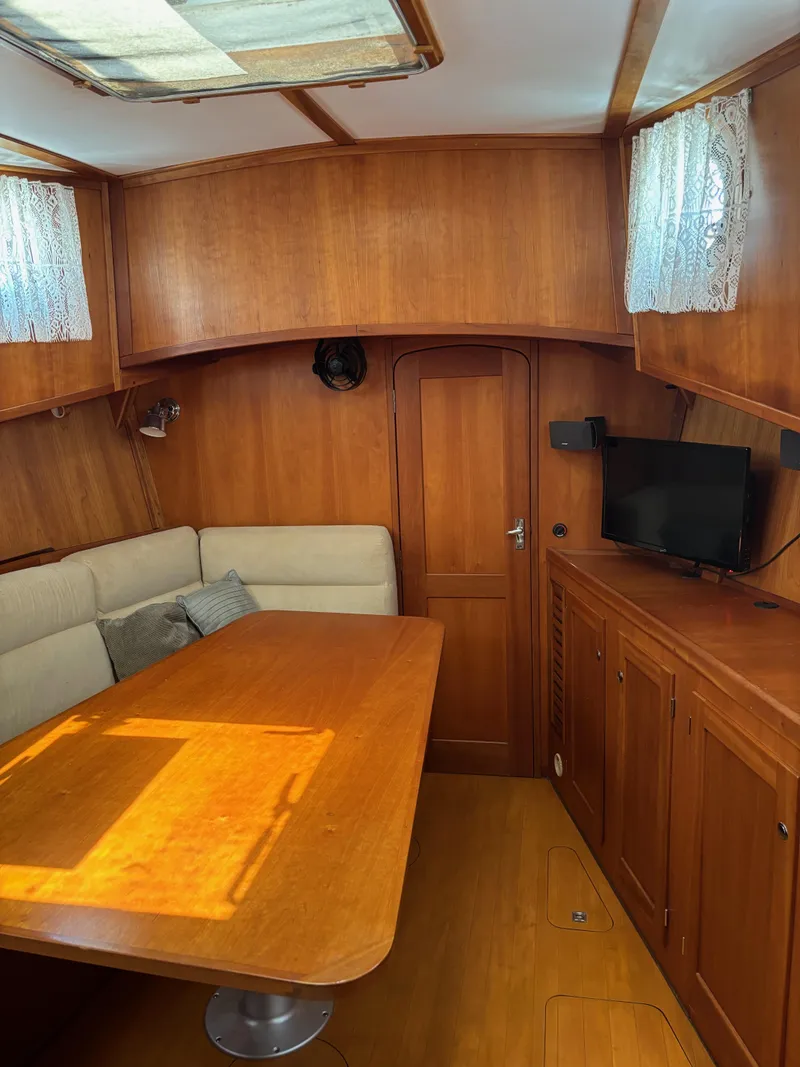 Slide: The Image of 1999 Diesel Duck Trawler interior with wooden dining area and TV. - 36