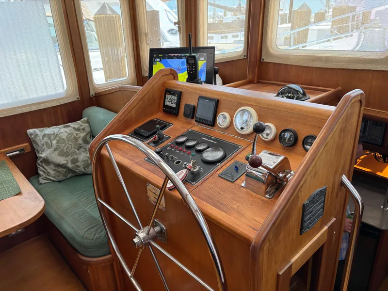 Slide: The Image of 1999 Diesel Duck Trawler helm with wooden dashboard, steering wheel, and navigation instruments. - 4