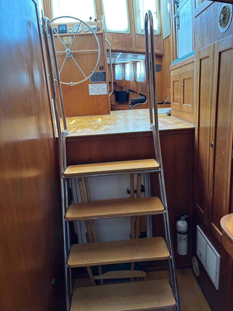 Slide: The Image of Interior of 1999 Diesel Duck Trawler with wooden stairs and steering wheel. - 44