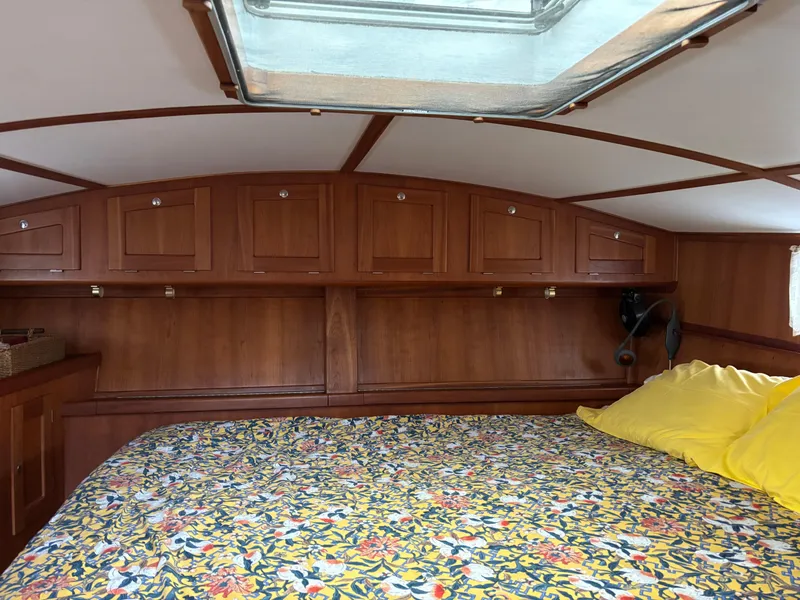 Slide: The Image of Cozy cabin interior of 1999 Diesel Duck Trawler with floral bedding and wooden storage cabinets. - 47