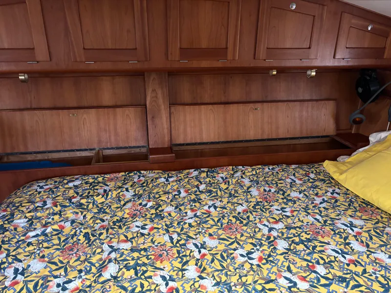 Slide: The Image of 1999 Diesel Duck Trawler interior with floral bedspread and wooden cabinetry. - 48