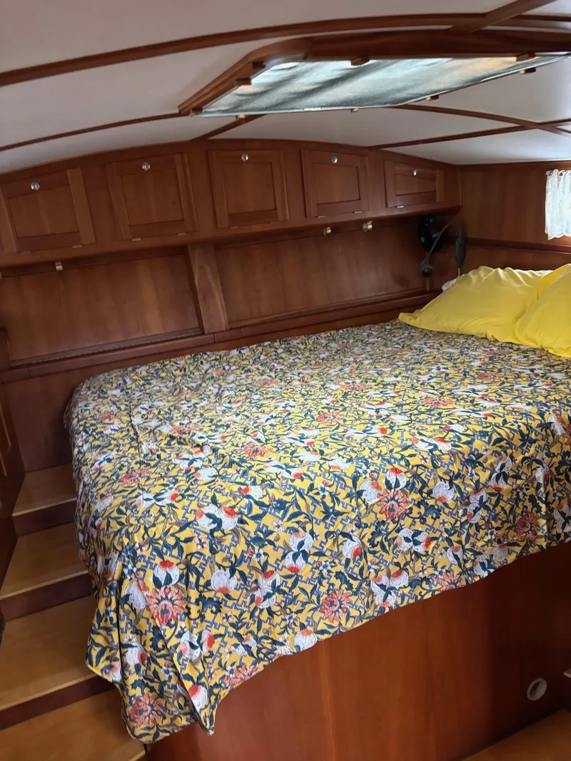 Slide: The Image of Cozy cabin interior of 1999 Diesel Duck Trawler with floral bedding and wooden cabinetry. - 50