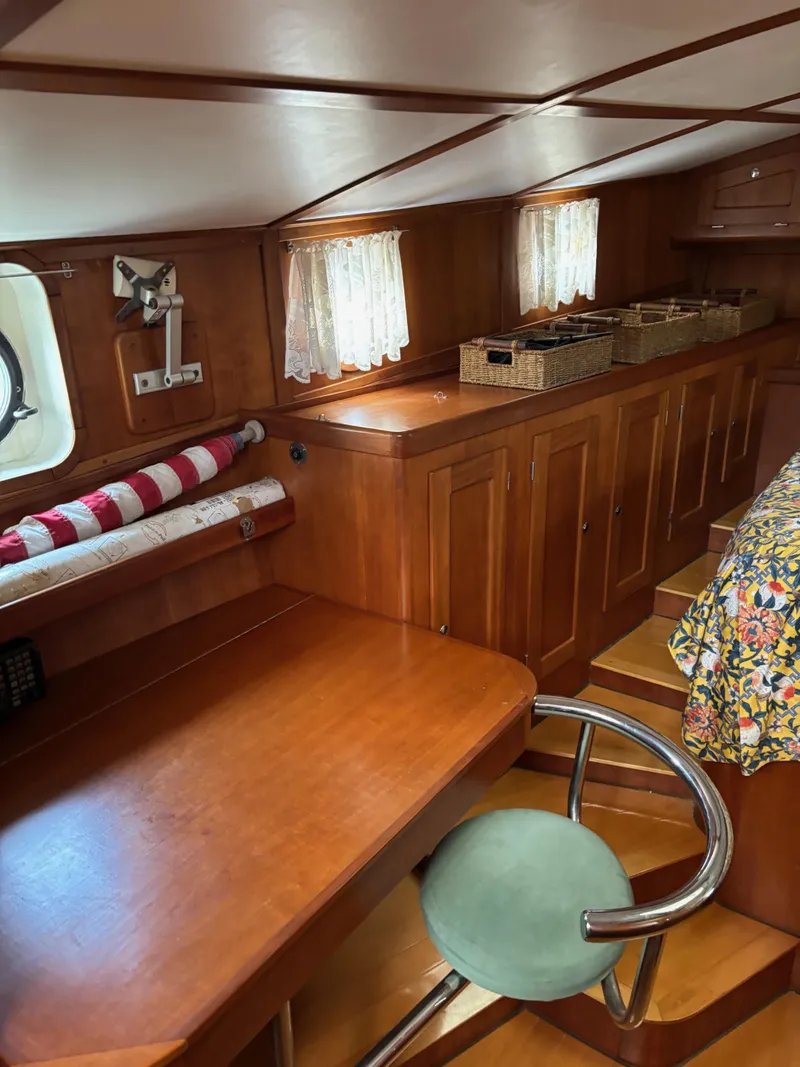 Slide: The Image of 1999 Diesel Duck Trawler interior with wooden cabinetry, desk, and chair. Cozy nautical design. - 51