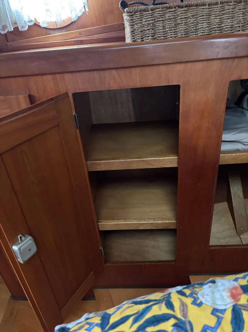 Slide: The Image of Wooden cabinet with open door and shelves inside a 1999 Diesel Duck Trawler. - 53