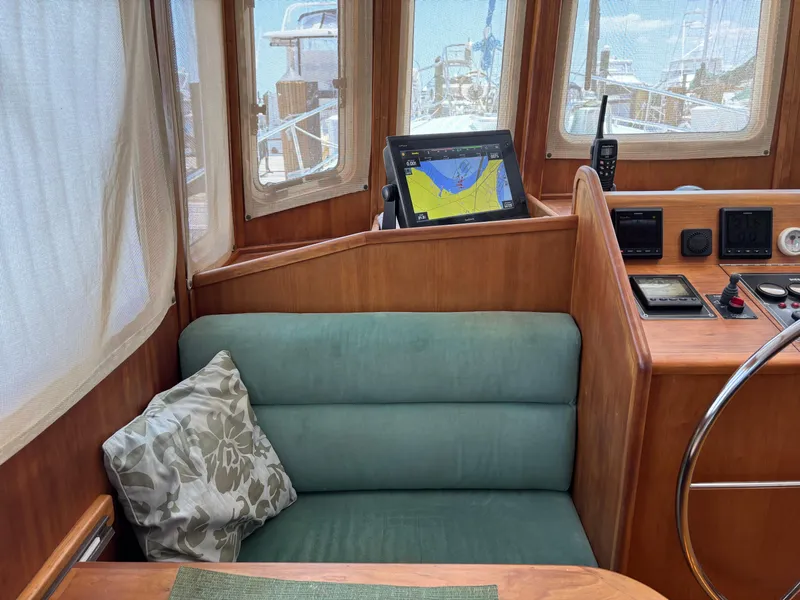 Slide: The Image of 1999 Diesel Duck Trawler interior with navigation equipment, cushioned seating, and wooden paneling. - 6