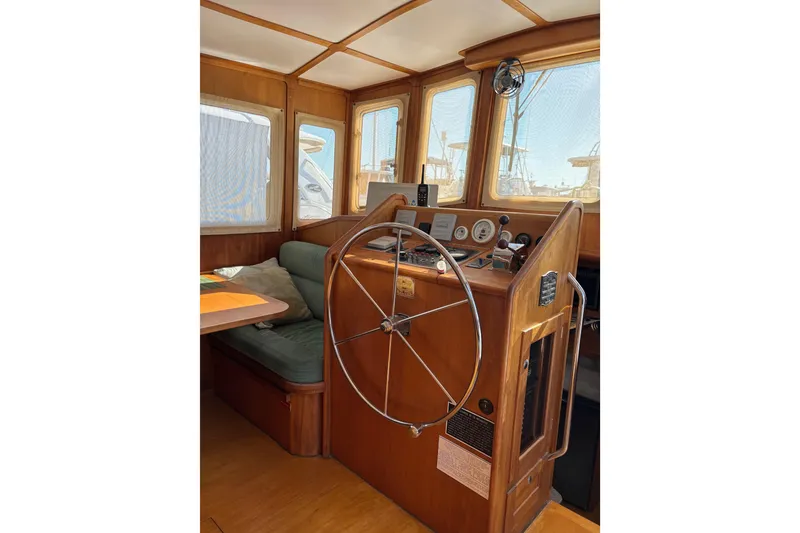 Slide: The Image of 1999 Diesel Duck Trawler helm with wooden interior and navigation instruments. - 92
