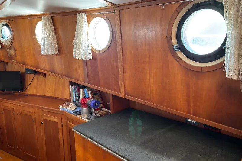 Slide: The Image of Interior of 1999 Diesel Duck Trawler with wooden paneling and porthole windows. - 93