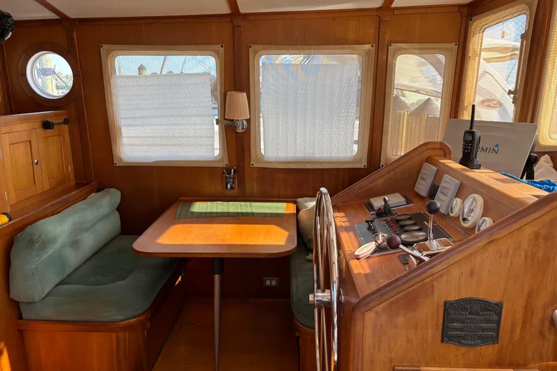 Slide: The Image of 1999 Diesel Duck Trawler interior with wooden helm, seating, and navigation equipment. - 94