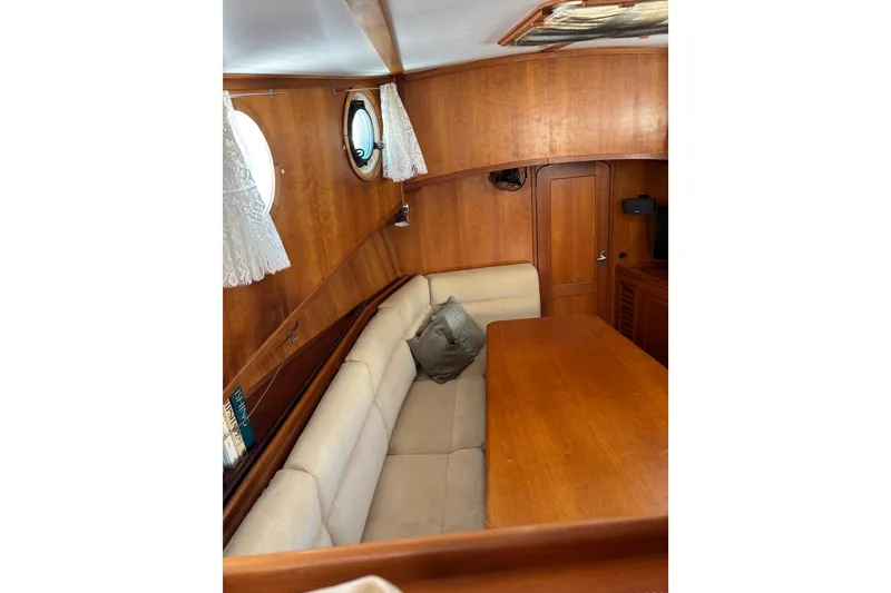 Slide: The Image of Cozy interior of 1999 Diesel Duck Trawler with wooden table and cushioned seating. - 96
