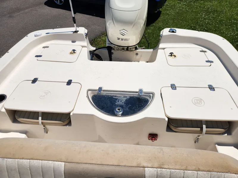 Slide: The Image of 2019 Carolina Skiff 198 DLV boat deck with storage compartments and outboard motor. - 12