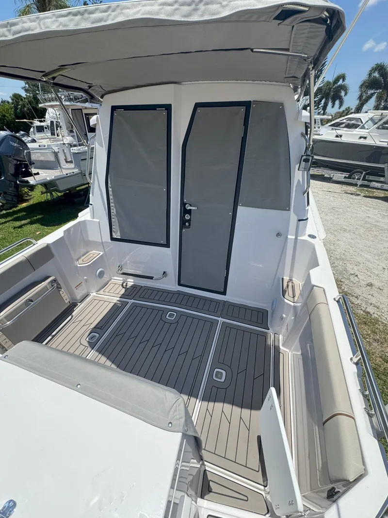 Slide: The Image of 2025 Cutwater C-248 Coupe boat with spacious deck and canopy, docked outdoors. - 3
