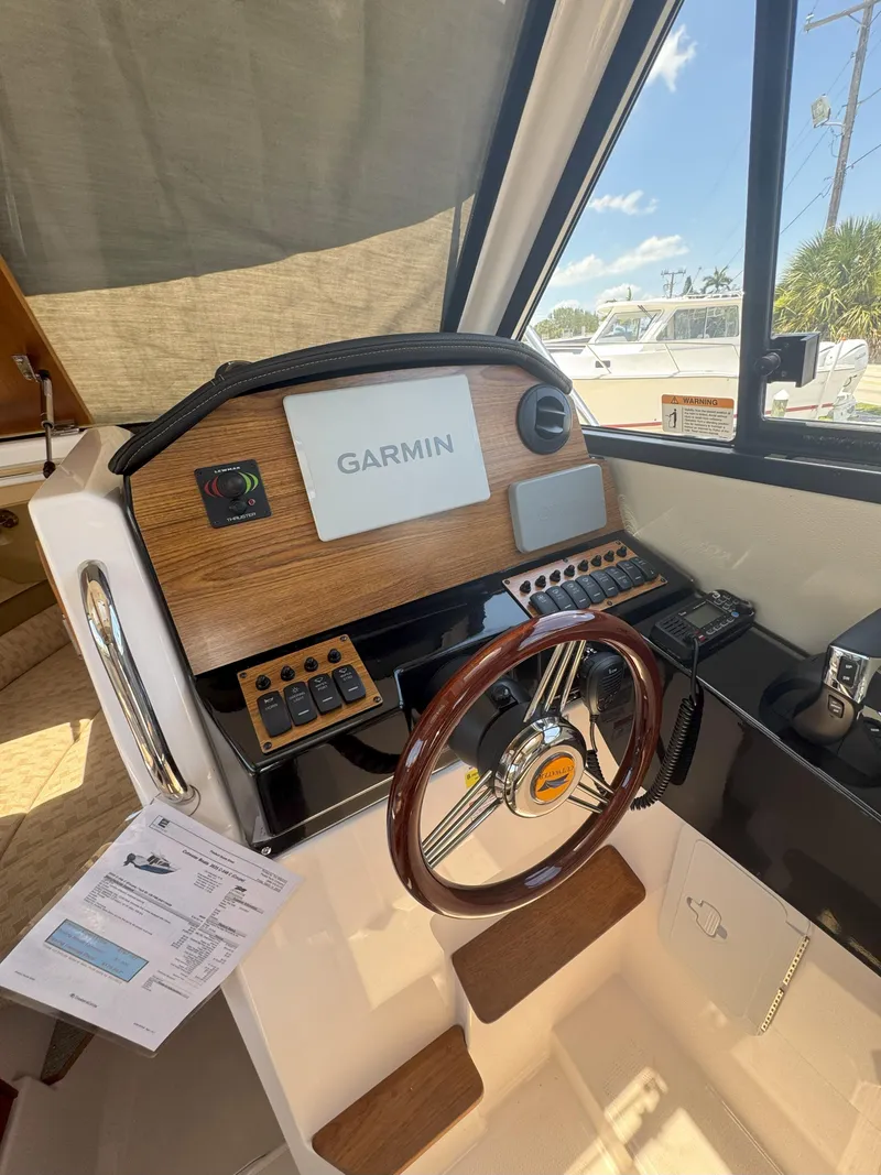 Slide: The Image of 2025 Cutwater C-248 Coupe helm with Garmin navigation system and wooden steering wheel. - 7