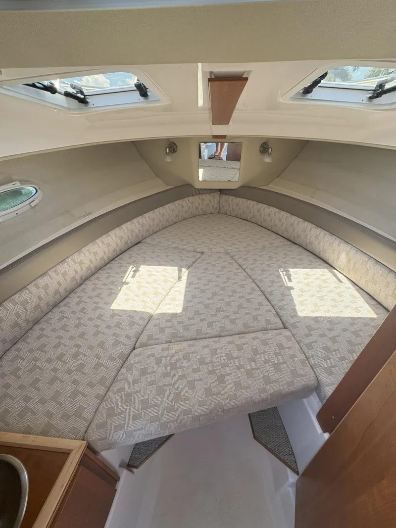 Slide: The Image of 2025 Cutwater C-248 Coupe interior cabin with cozy bed and natural light. - 9
