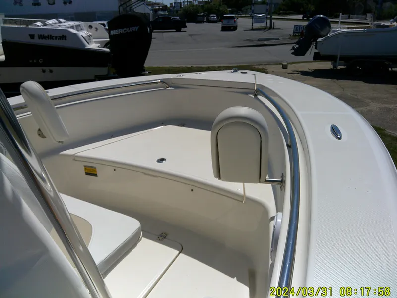 Slide: The Image of 2024 Bulls Bay 200 CC boat interior with seating and storage, parked outdoors. - 10