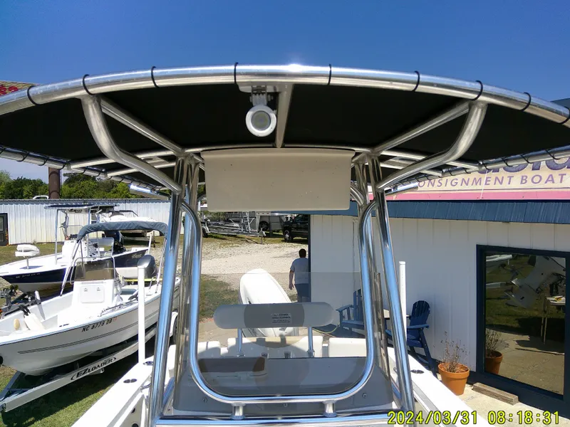 Slide: The Image of 2024 Bulls Bay 200 CC boat with T-top, displayed outdoors on a sunny day. - 12
