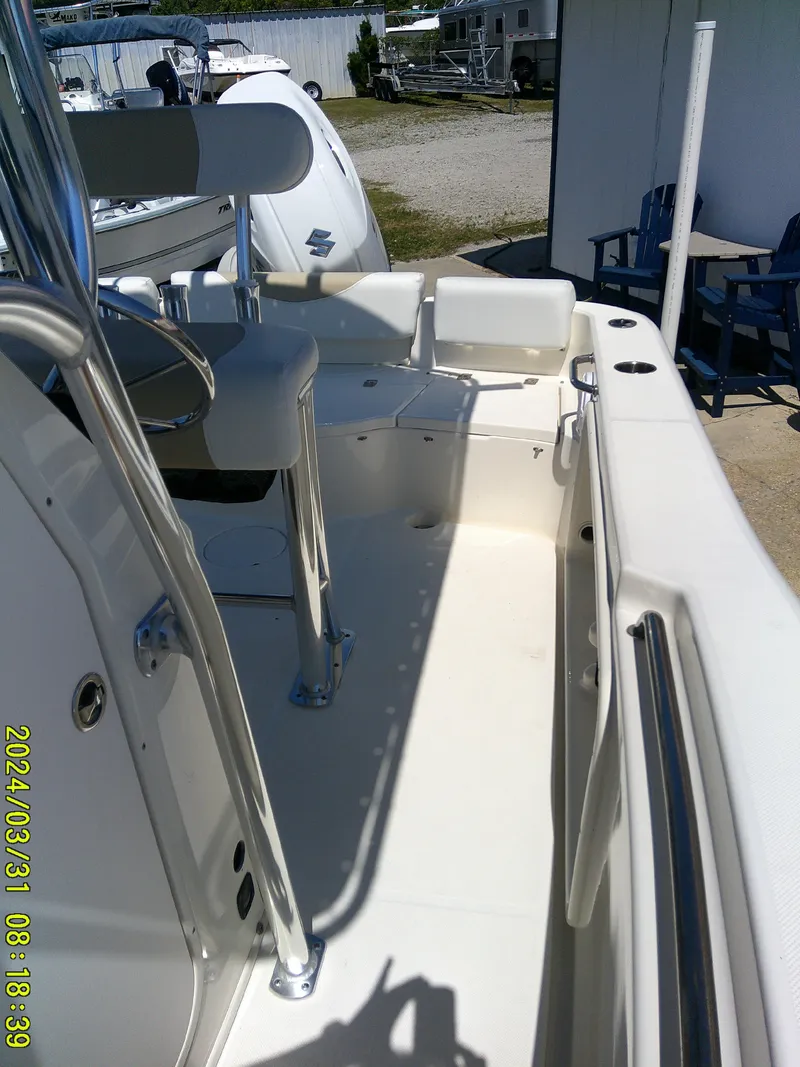 Slide: The Image of 2024 Bulls Bay 200 CC boat interior with seating and console, docked outdoors. - 13