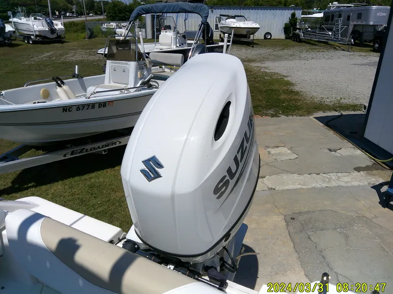 Slide: The Image of 2024 Bulls Bay 200 CC boat with Suzuki outboard motor in a marina setting. - 26