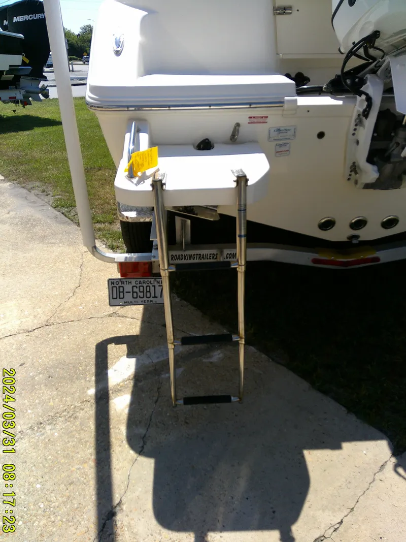 Slide: The Image of 2024 Bulls Bay 200 CC boat with rear ladder and motor, parked on concrete. - 8