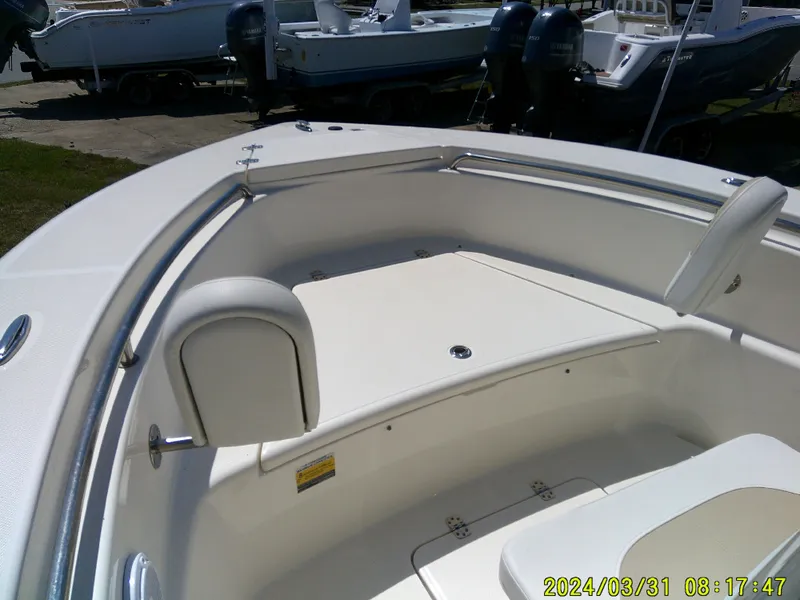 Slide: The Image of 2024 Bulls Bay 200 CC boat interior with seating and storage, photographed in a marina setting. - 9