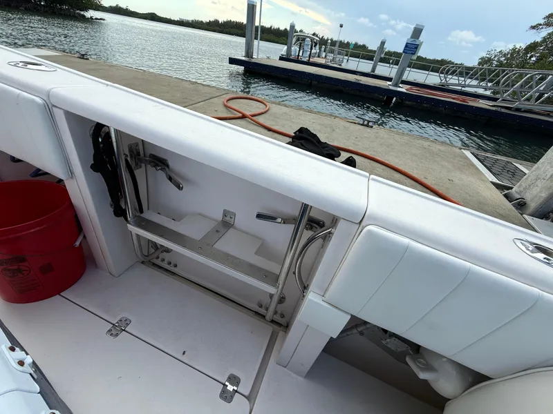Slide: The Image of 2006 Intrepid 350 Center Console boat interior at dock, featuring storage compartment and seating. - 20