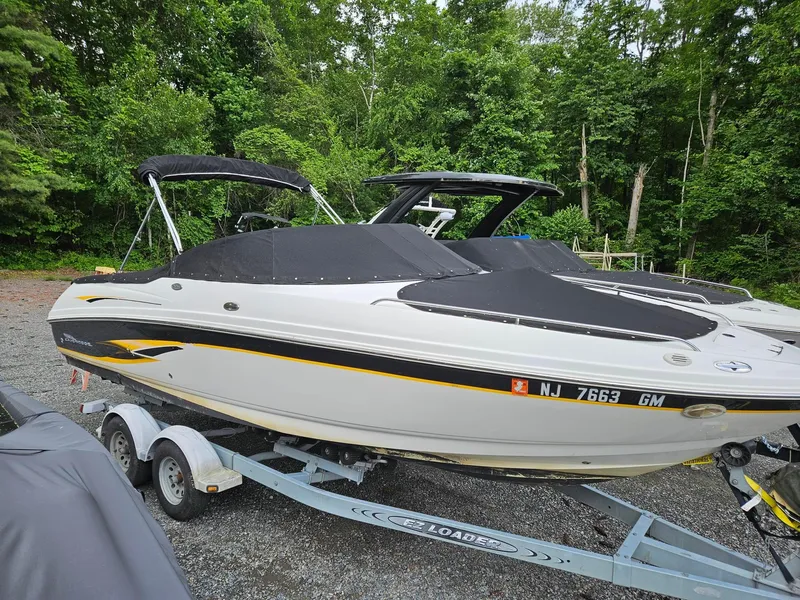 Slide: The Image of 2000 Chaparral 230 SSi boat on trailer, covered and parked in a wooded area. - 18