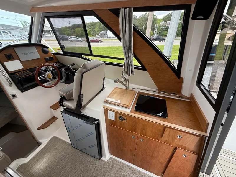 Slide: The Image of 2025 Cutwater C-248 Coupe interior with helm, wooden cabinetry, and modern navigation equipment. - 12