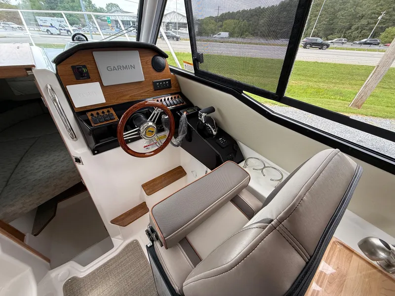 Slide: The Image of 2025 Cutwater C-248 Coupe interior with Garmin navigation, wood accents, and comfortable seating. - 13