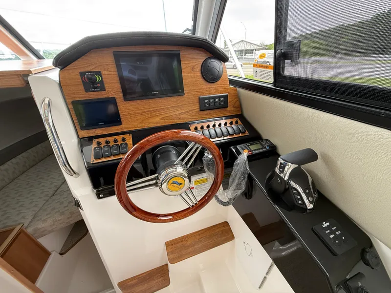 Slide: The Image of 2025 Cutwater C-248 Coupe helm with wood accents, steering wheel, and control panel. - 14