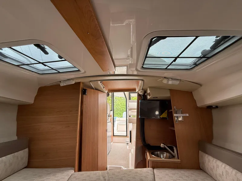 Slide: The Image of Interior of 2025 Cutwater C-248 Coupe, featuring skylights, wood accents, and compact kitchenette. - 17