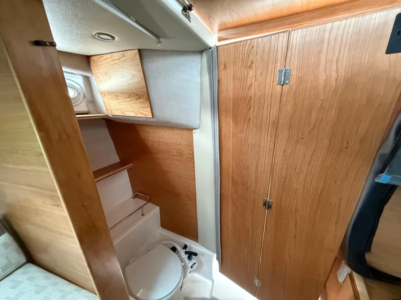 Slide: The Image of Interior of 2025 Cutwater C-248 Coupe, featuring compact wooden bathroom design. - 18