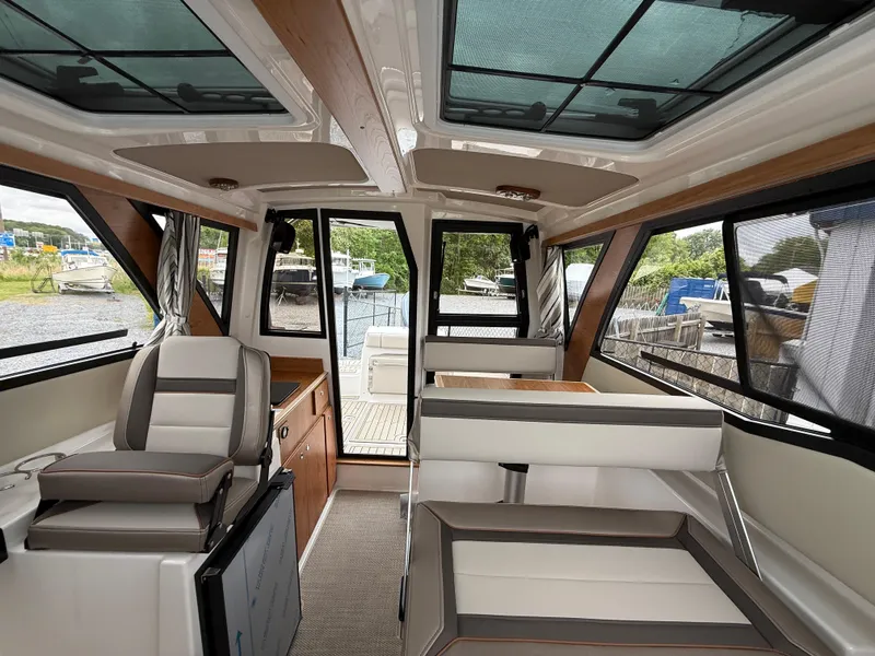 Slide: The Image of Interior of 2025 Cutwater C-248 Coupe boat, featuring modern seating and panoramic windows. - 19
