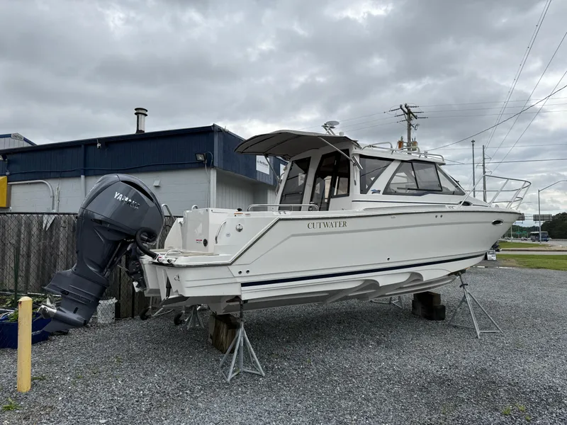 Slide: The Image of 2025 Cutwater C-248 Coupe boat on stands, outdoor display, overcast sky. - 2