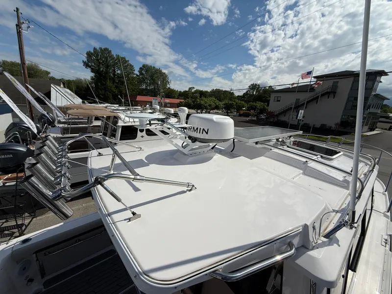 Slide: The Image of 2025 Cutwater C-288 Coupe boat with Garmin equipment, docked under a partly cloudy sky. - 10