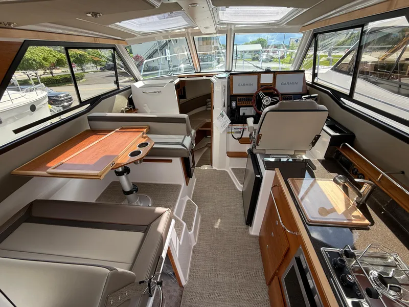 Slide: The Image of Interior of 2025 Cutwater C-288 Coupe boat, featuring seating, helm, and kitchenette. - 11