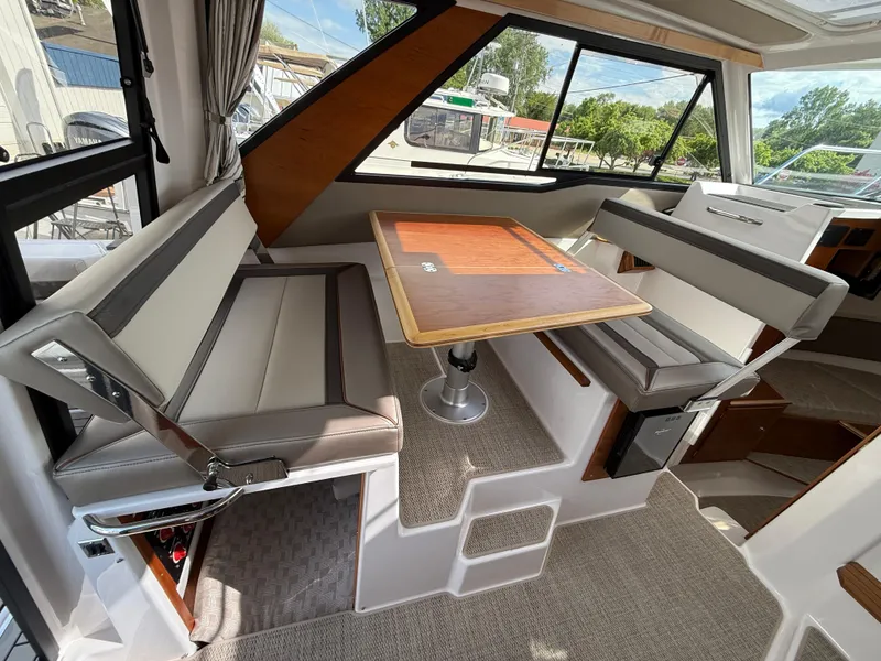 Slide: The Image of 2025 Cutwater C-288 Coupe interior with dining area and panoramic windows. - 12
