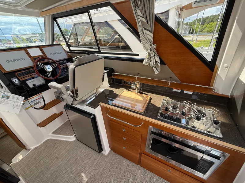 Slide: The Image of Interior of 2025 Cutwater C-288 Coupe featuring helm, kitchen, and navigation equipment. - 14