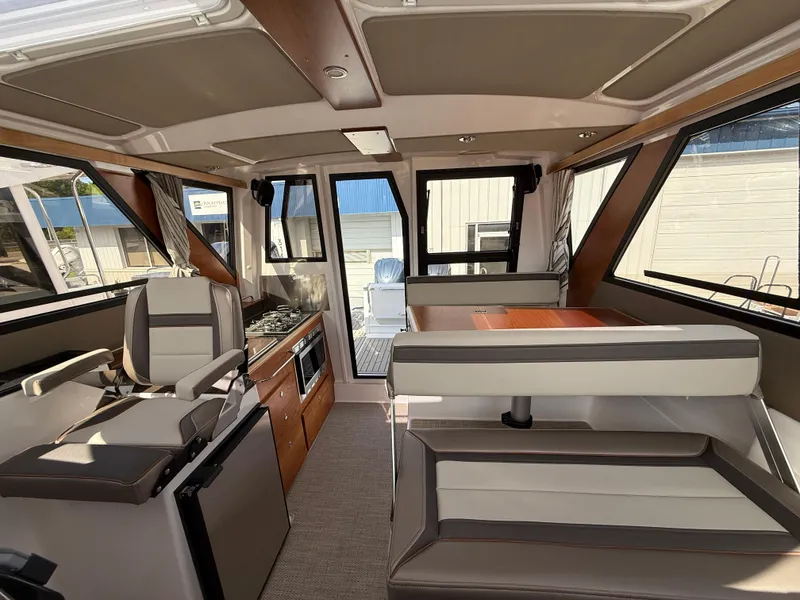 Slide: The Image of Interior of 2025 Cutwater C-288 Coupe, featuring modern seating and kitchen area. - 17