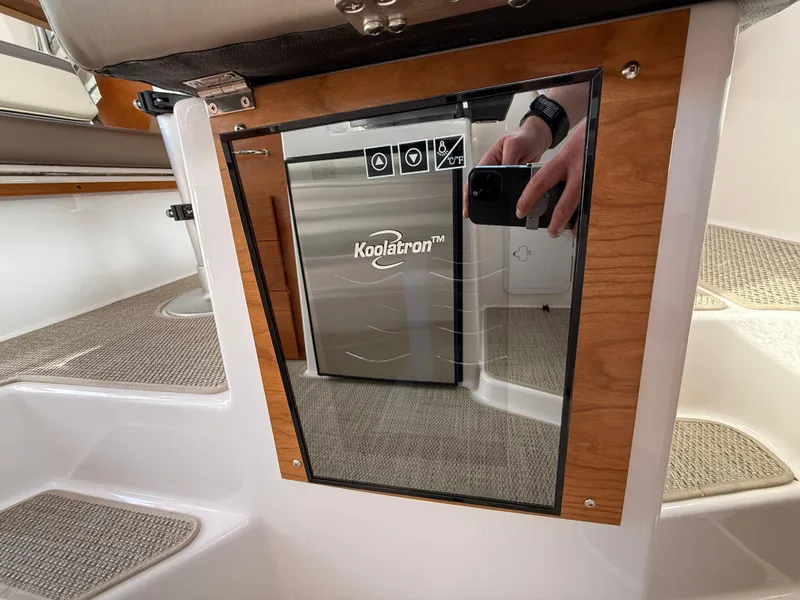 Slide: The Image of 2025 Cutwater C-288 Coupe interior with Koolatron fridge and wooden accents. - 19