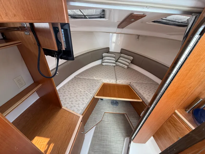 Slide: The Image of 2025 Cutwater C-288 Coupe interior cabin with cozy seating and wooden accents. - 20