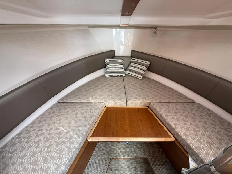 Slide: The Image of 2025 Cutwater C-288 Coupe interior with cozy seating and wooden table. - 21