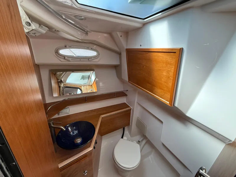 Slide: The Image of 2025 Cutwater C-288 Coupe bathroom with modern fixtures and wooden accents. - 23