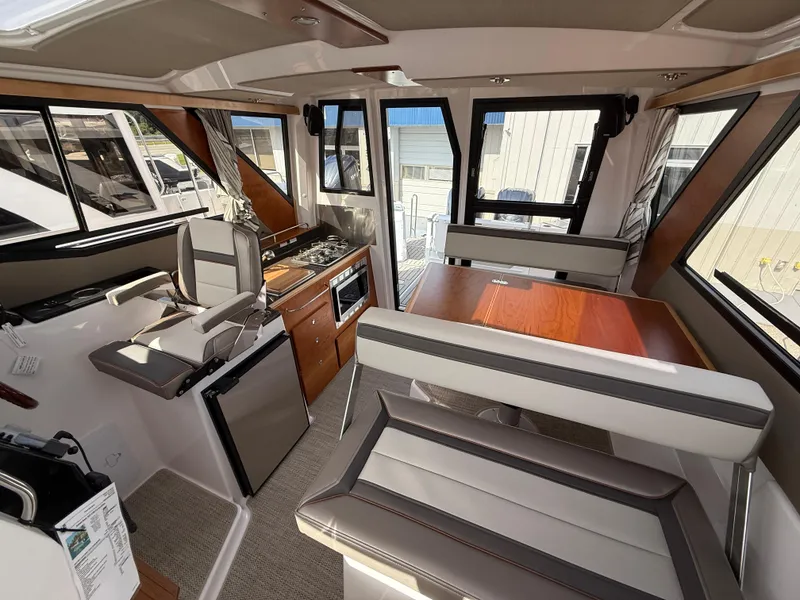 Slide: The Image of 2025 Cutwater C-288 Coupe interior with modern seating, dining area, and kitchenette. - 25