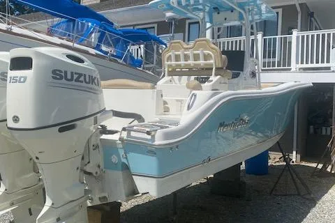 The Image of 2018 NauticStar 2602 Legacy boat with Suzuki 150 engine, docked outdoors. - 0