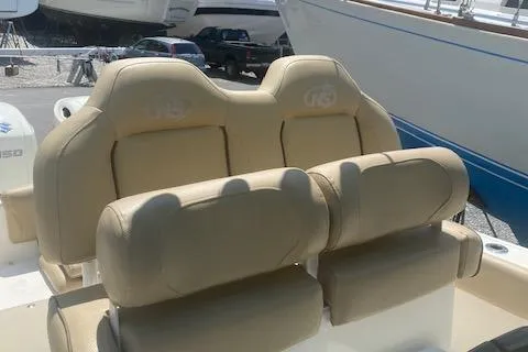 Slide: The Image of 2018 NauticStar 2602 Legacy boat seats, beige upholstery, outdoor setting. - 11