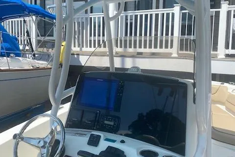 Slide: The Image of 2018 NauticStar 2602 Legacy boat dashboard with steering wheel and navigation display. - 14