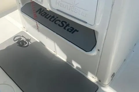 Slide: The Image of 2018 NauticStar 2602 Legacy boat interior with branded mats and storage compartment. - 15