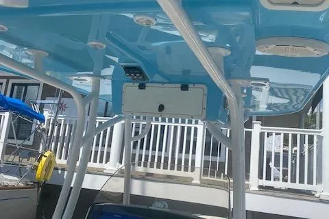 Slide: The Image of 2018 NauticStar 2602 Legacy boat with blue T-top and white supports. - 16